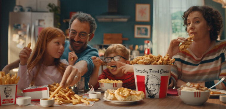 Family of four eat KFC together. Family of four eat KFC together.